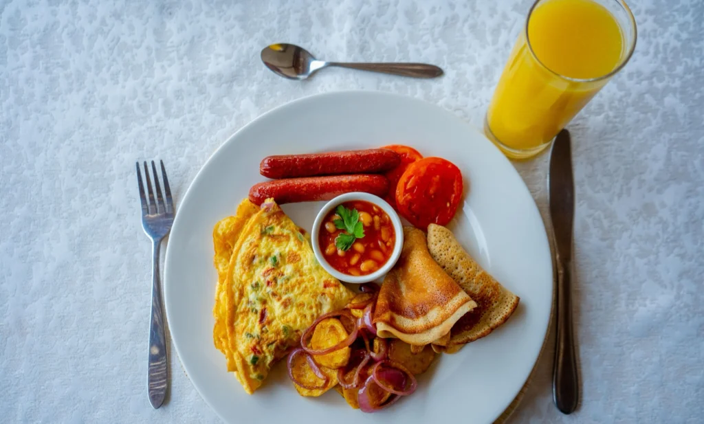 Breakfast spread with eggs, fruit and juice, seen from above