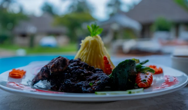 Plated beef dish with the turquoise pool behind
