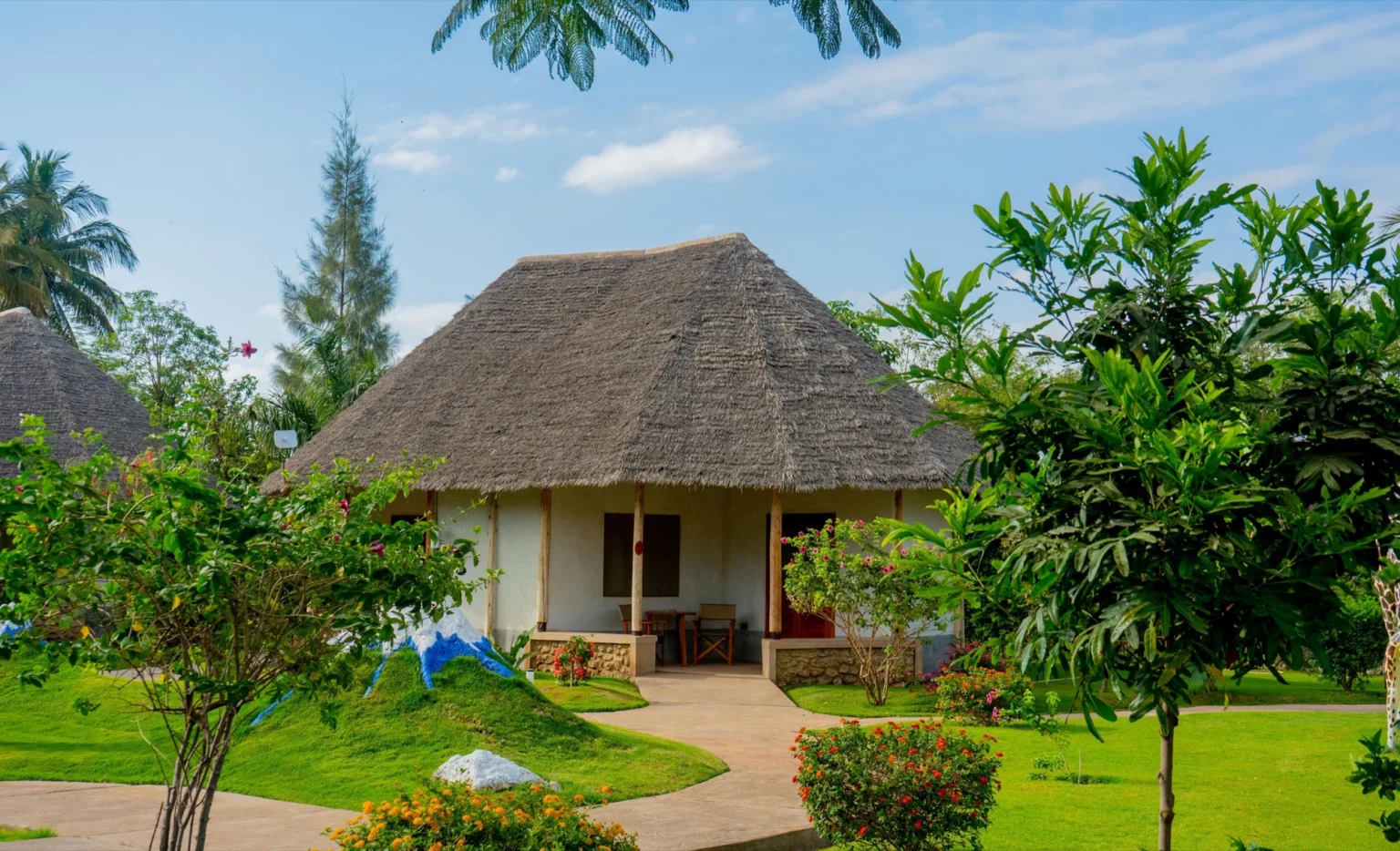 Round whitewashed cottage under a makuti thatched roof